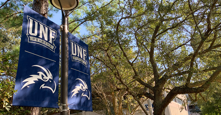 UNF Osprey banners with trees in the background